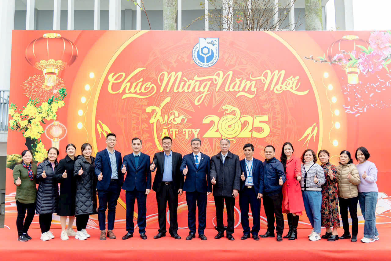 A group of people standing in front of a banner Description automatically generated