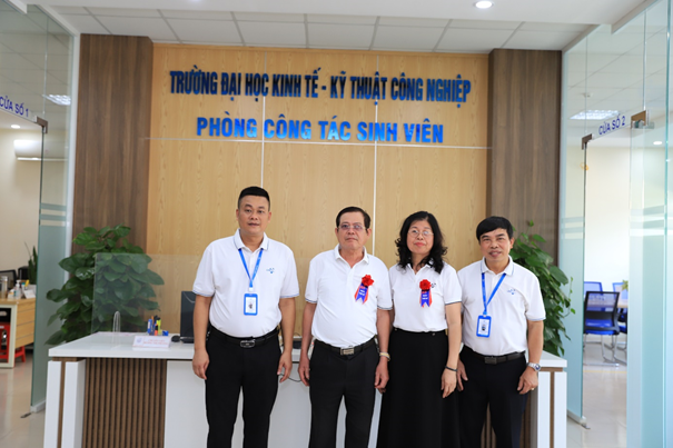 A group of people standing in front of a desk

Description automatically generated
