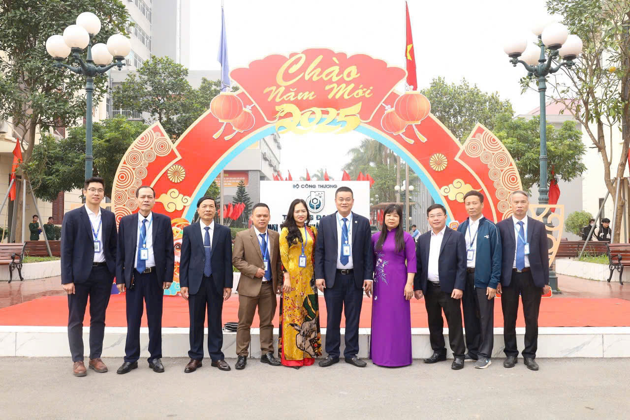A group of people standing in front of a sign Description automatically generated