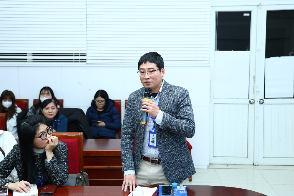 A person holding a microphone in front of a group of people AI-generated content may be incorrect.