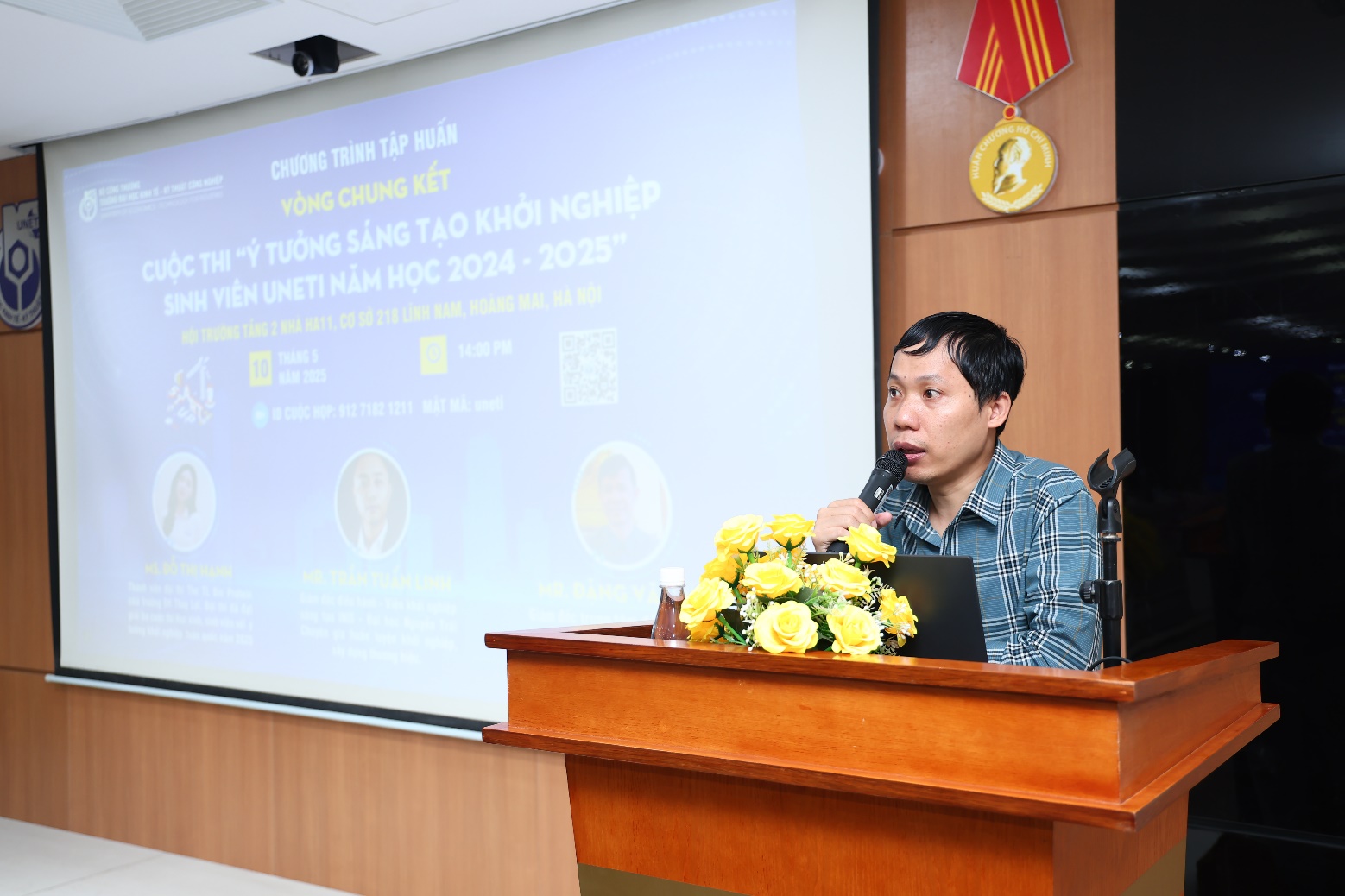 A person standing at a podium with a microphone Description automatically generated