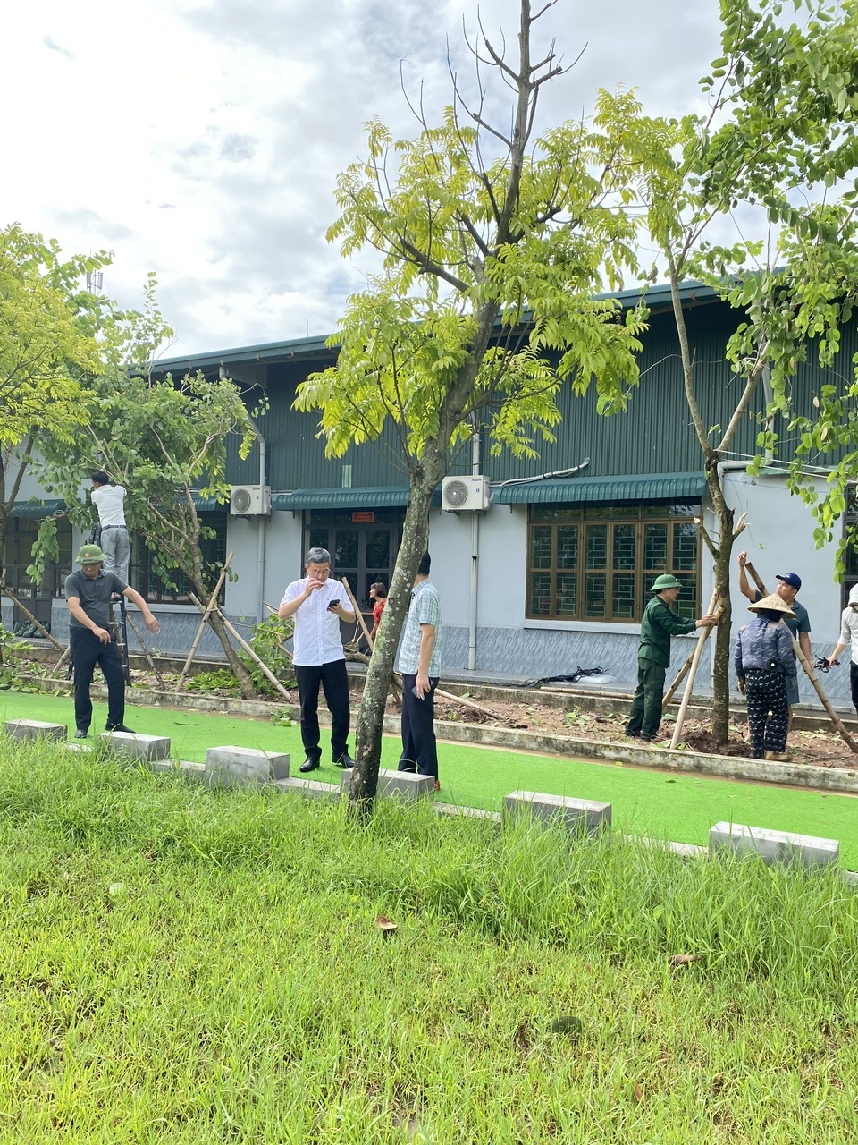A group of people standing in front of a building Description automatically generated