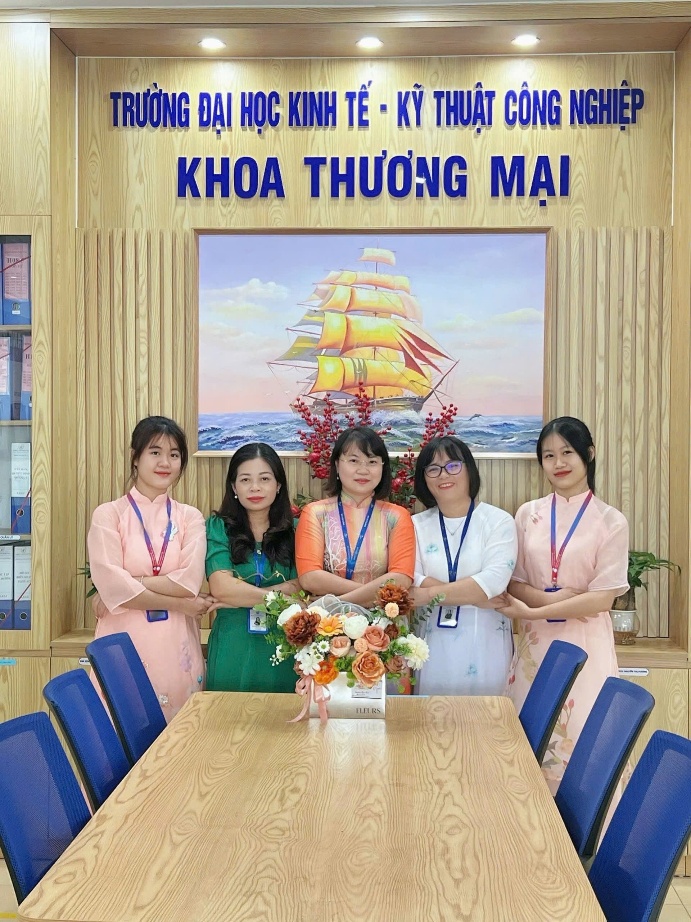 A group of women standing in front of a table Description automatically generated