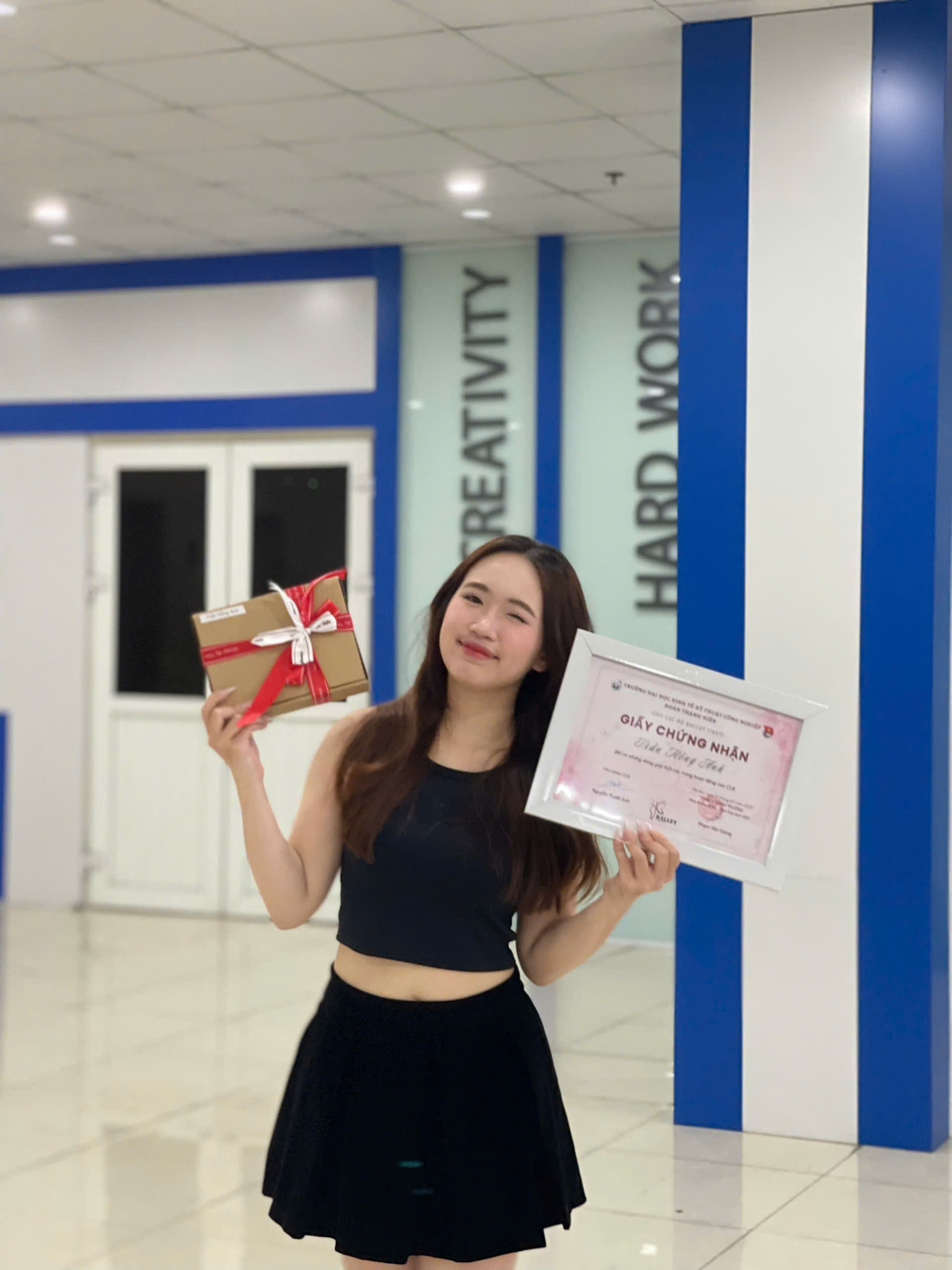 A person holding a certificate and a gift AI-generated content may be incorrect.