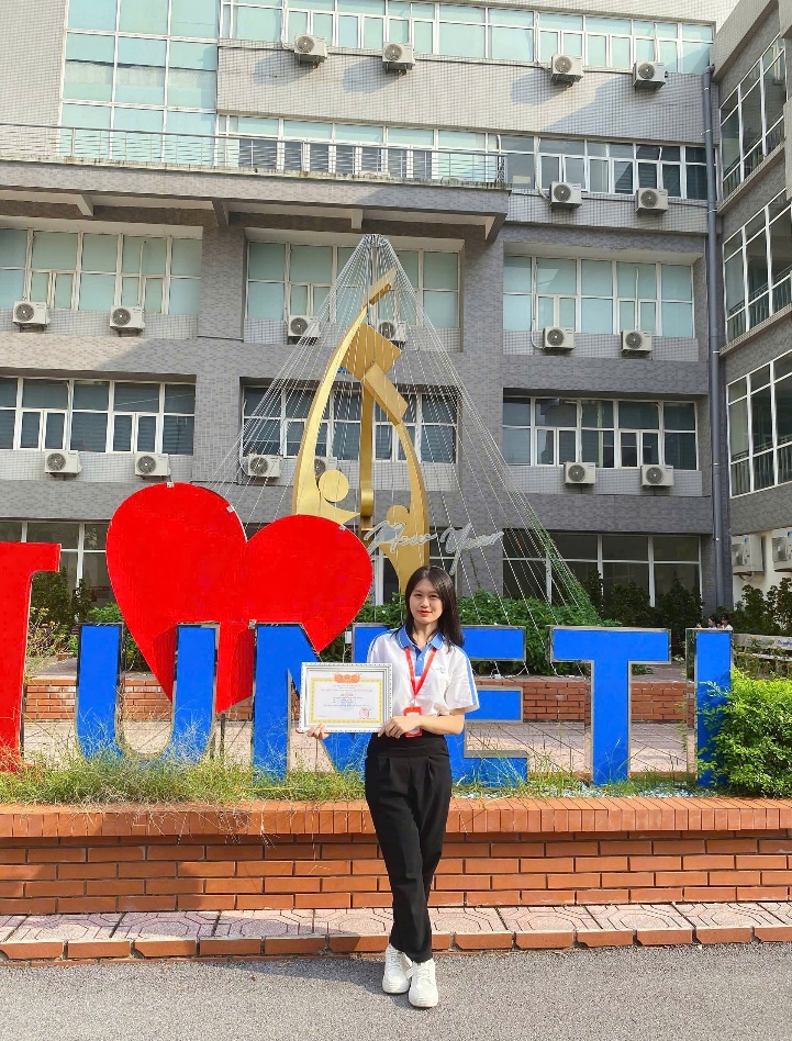 A person standing in front of a building Description automatically generated