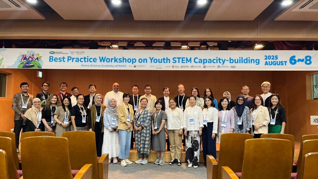A group of people standing in front of a banner

Description automatically generated