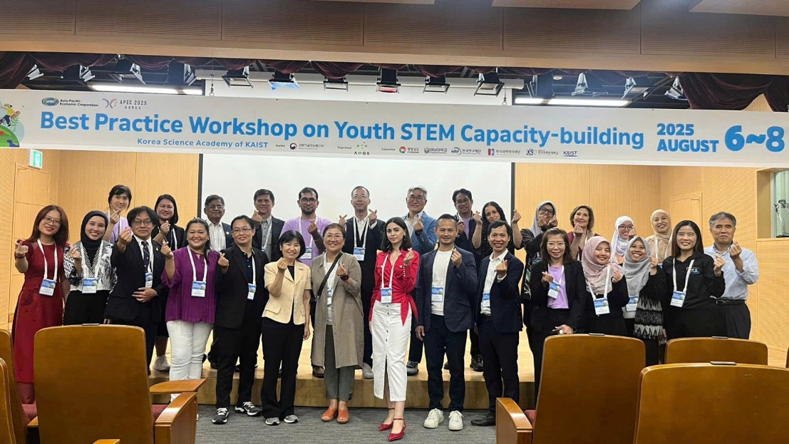 A group of people standing in front of a banner

Description automatically generated