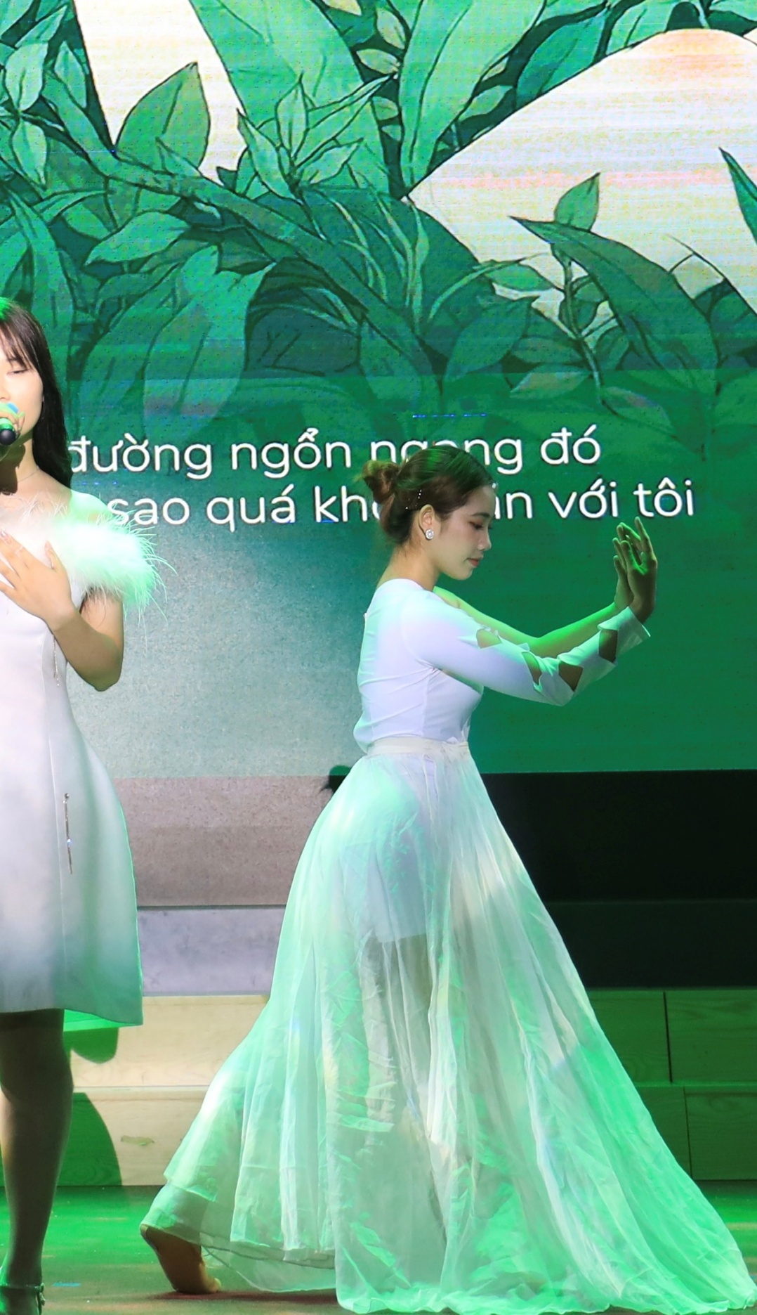 A person in white dress performing on stage AI-generated content may be incorrect.