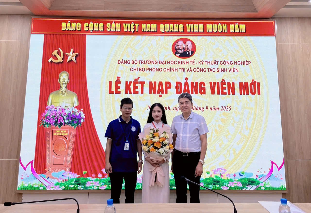 A group of people standing in front of a large screen Description automatically generated