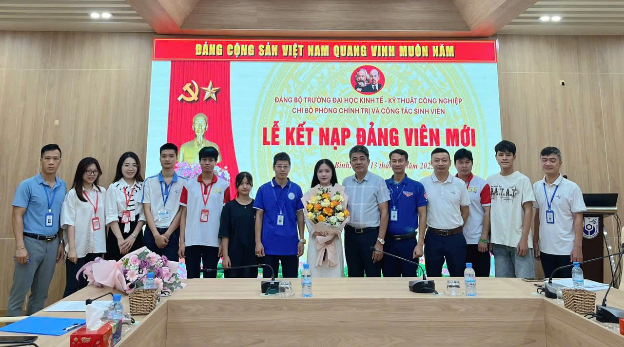 A group of people standing in front of a large screen Description automatically generated