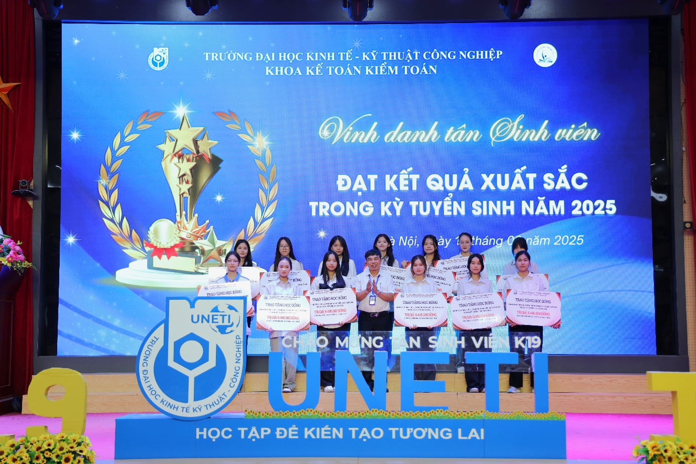 A group of people standing in front of a large sign Description automatically generated