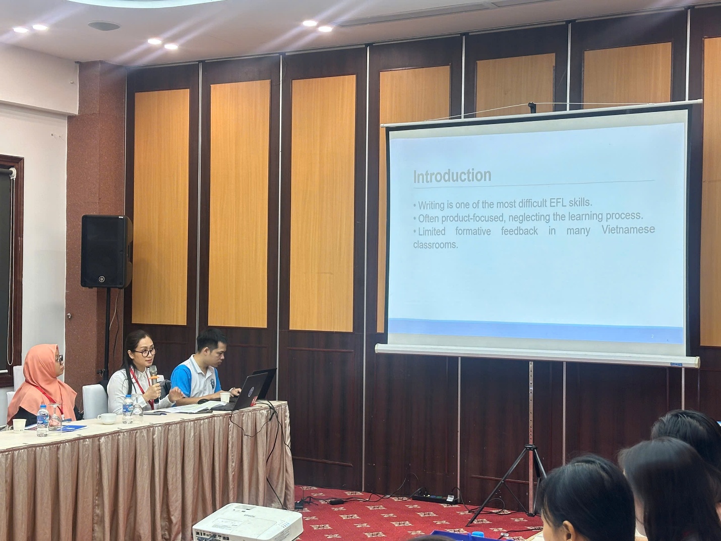 A group of people sitting at a table in front of a screen AI-generated content may be incorrect.