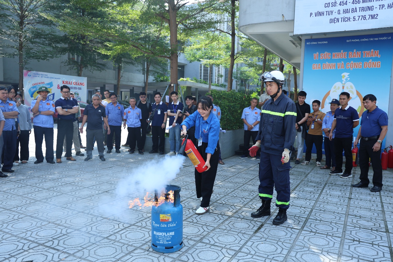 A group of people standing around a fire extinguisher

Description automatically generated