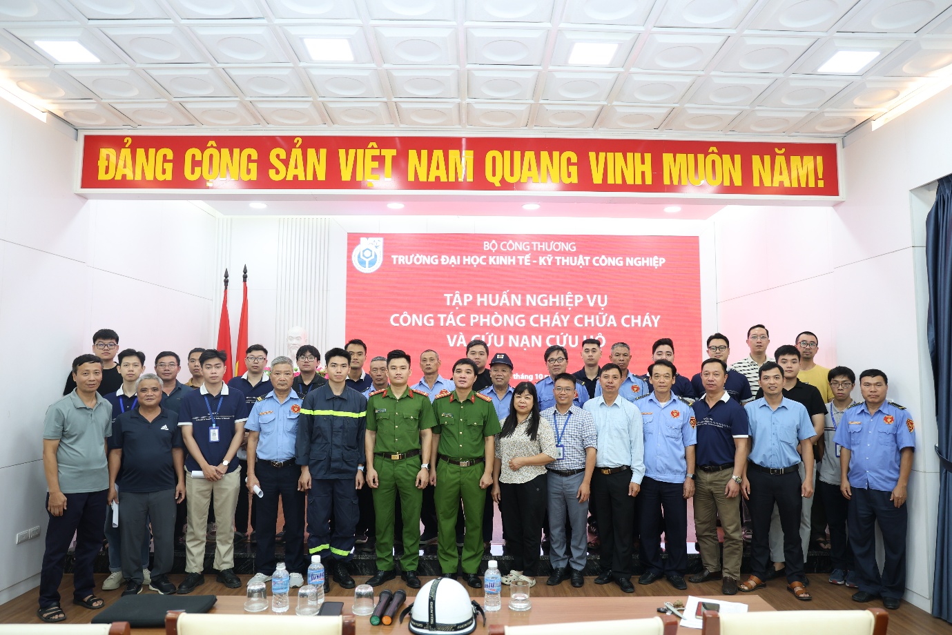 A group of people standing in front of a red banner

Description automatically generated