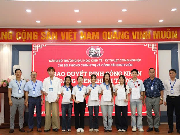 A group of people standing in front of a red banner

Description automatically generated