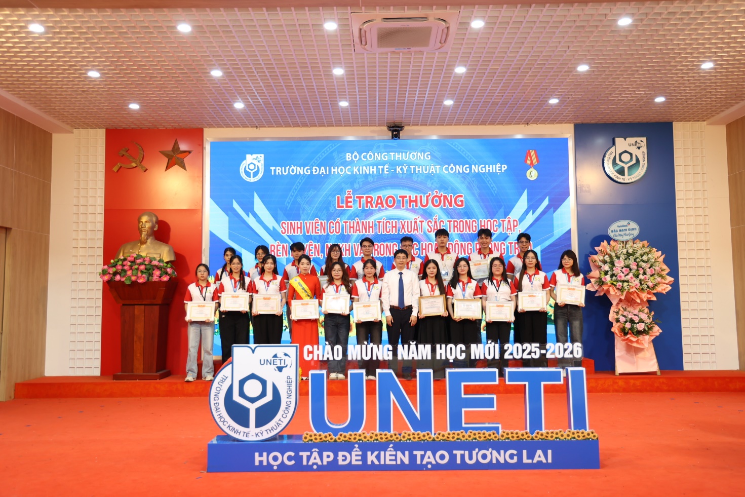 A group of people standing in front of a sign Description automatically generated
