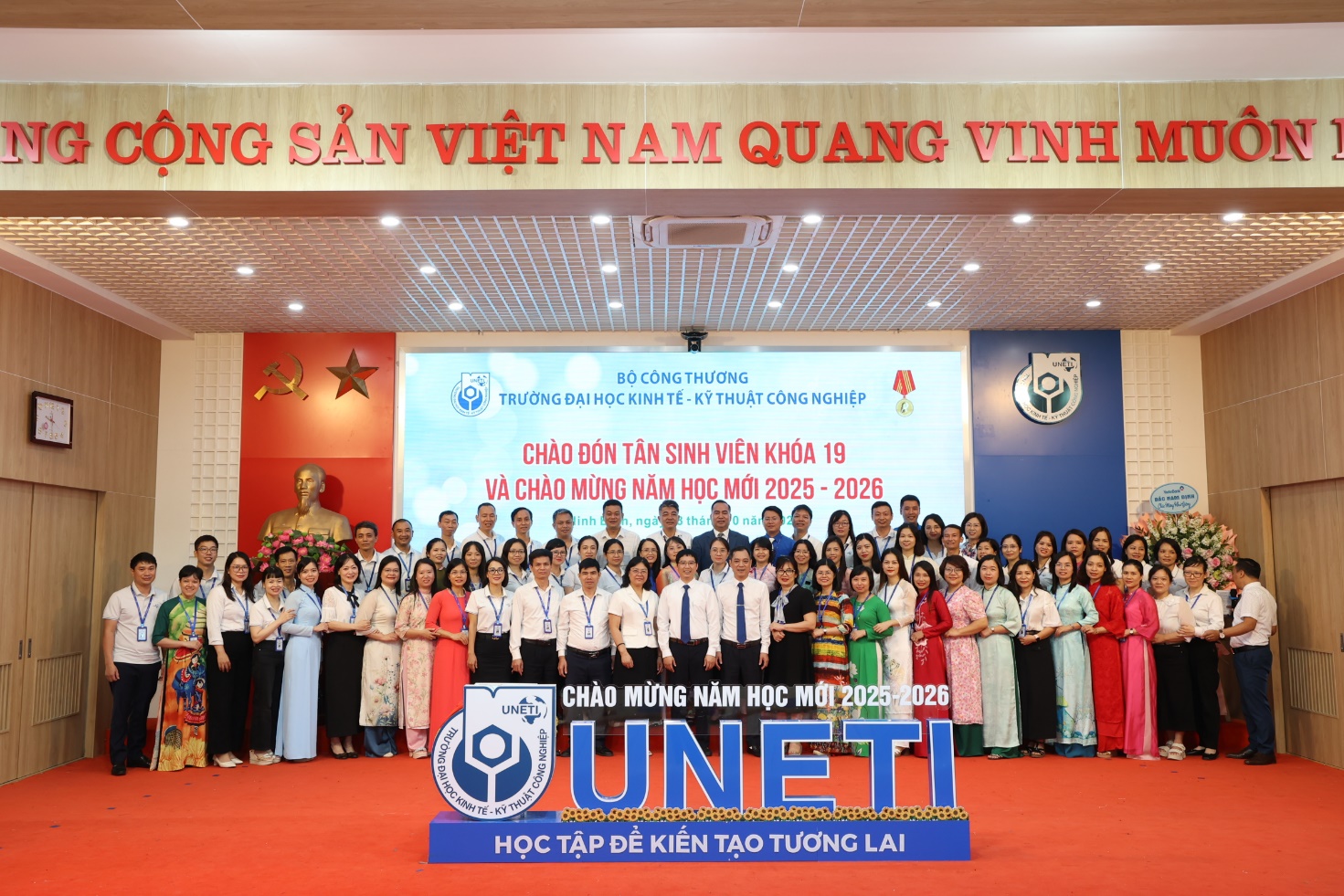 A group of people standing in front of a sign Description automatically generated