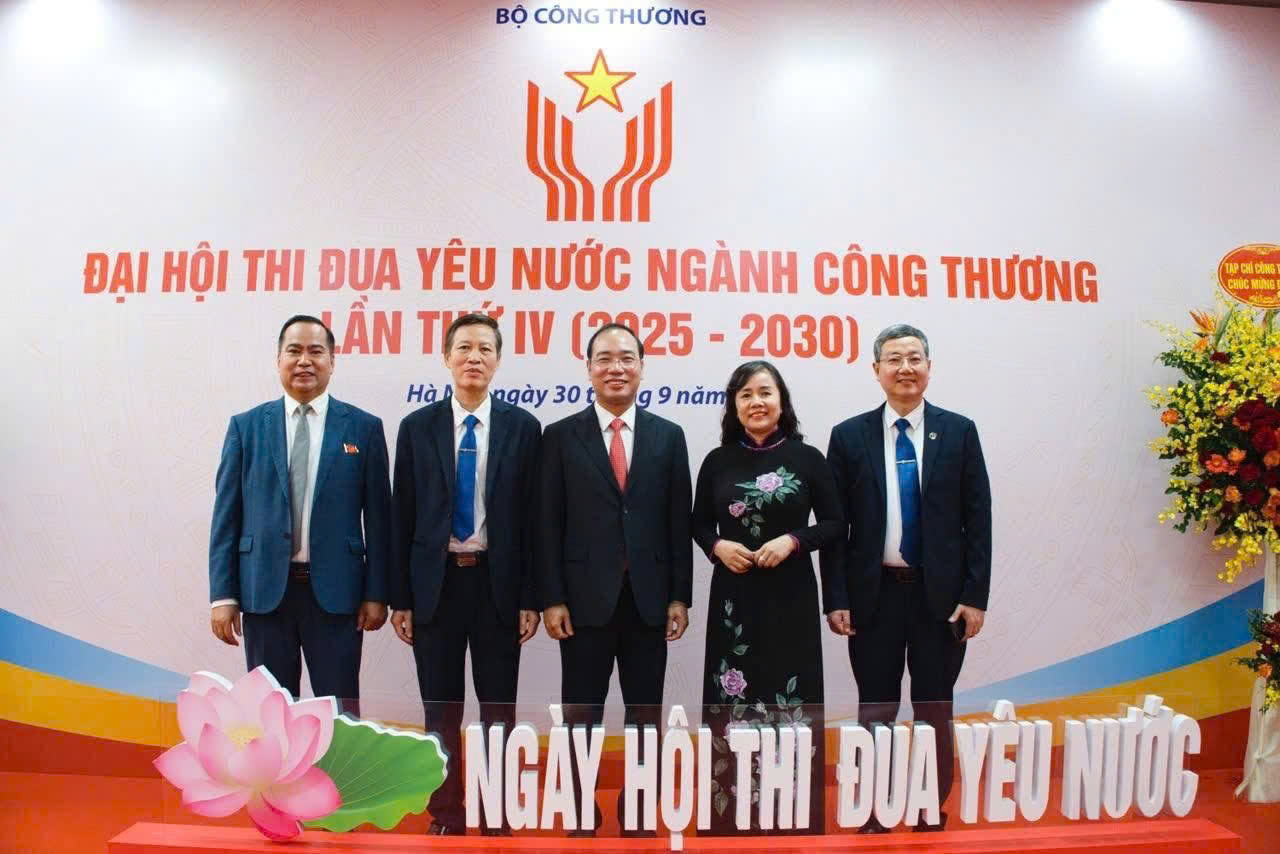 A group of people standing in front of a sign Description automatically generated