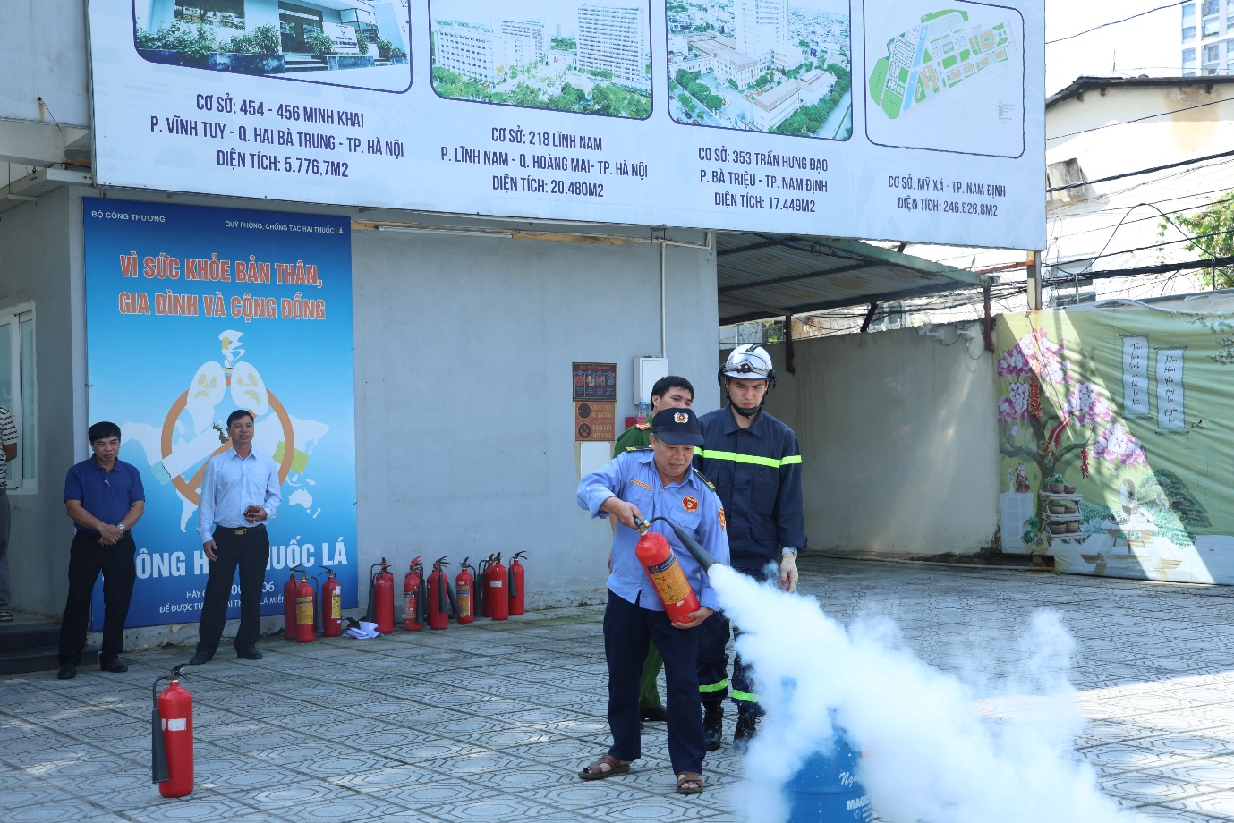 A group of people standing outside with fire extinguisher

Description automatically generated