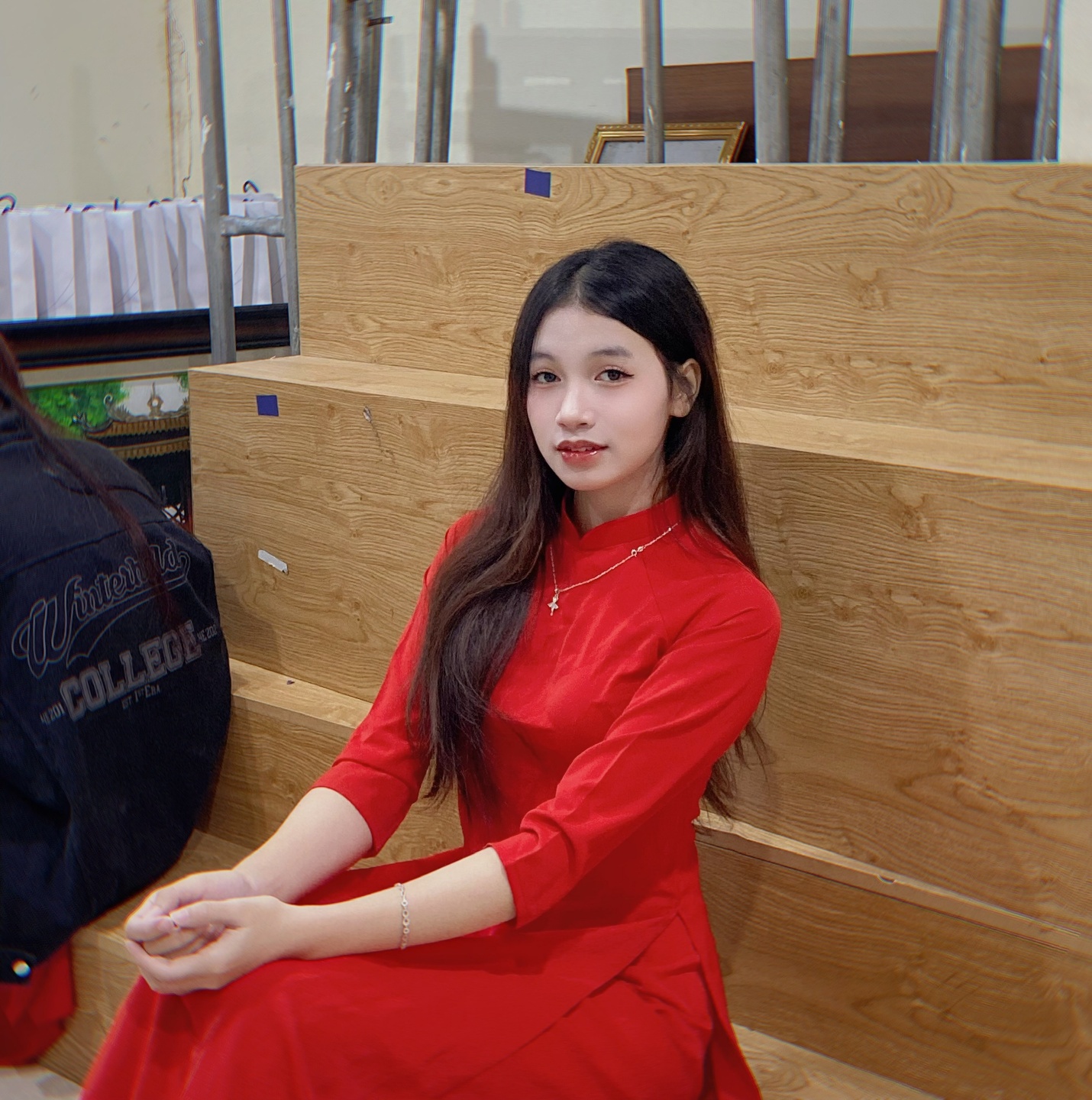 A person in a red dress sitting on a wooden bench

AI-generated content may be incorrect.