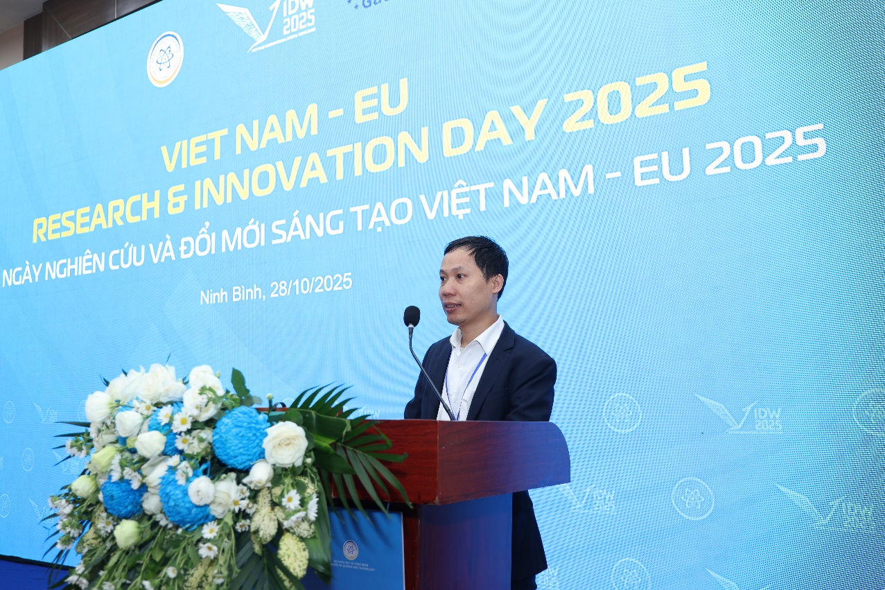 A person standing at a podium with a microphone Description automatically generated