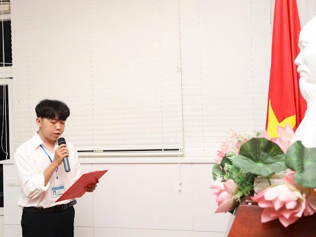 A person standing in front of a flag

Description automatically generated