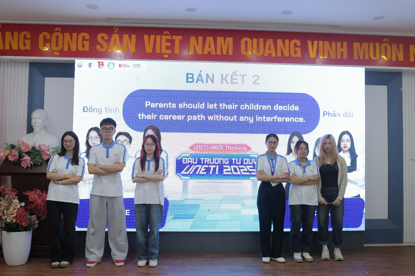 A group of people standing in front of a large screen AI-generated content may be incorrect.