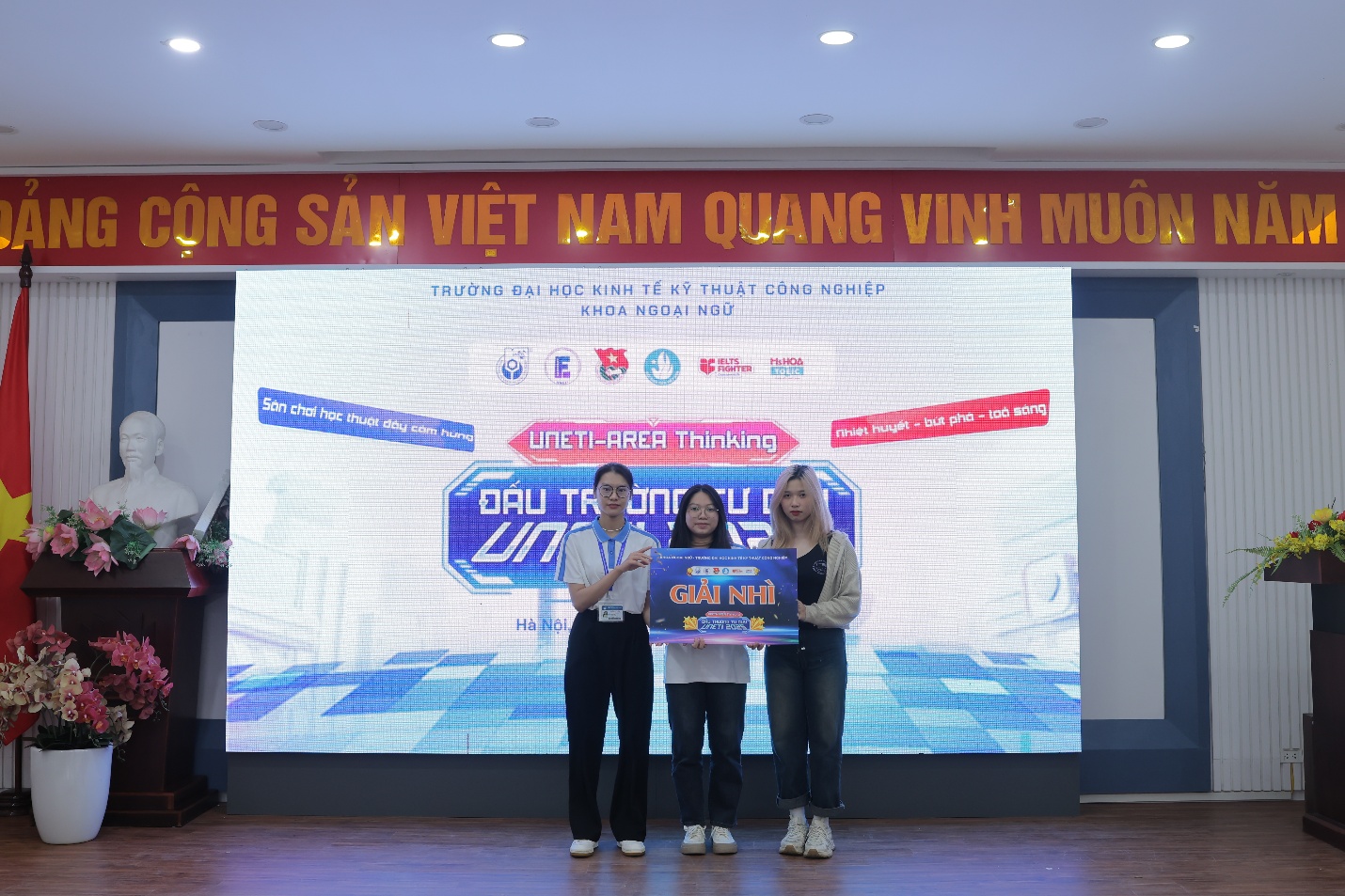 A group of people standing in front of a large screen AI-generated content may be incorrect.