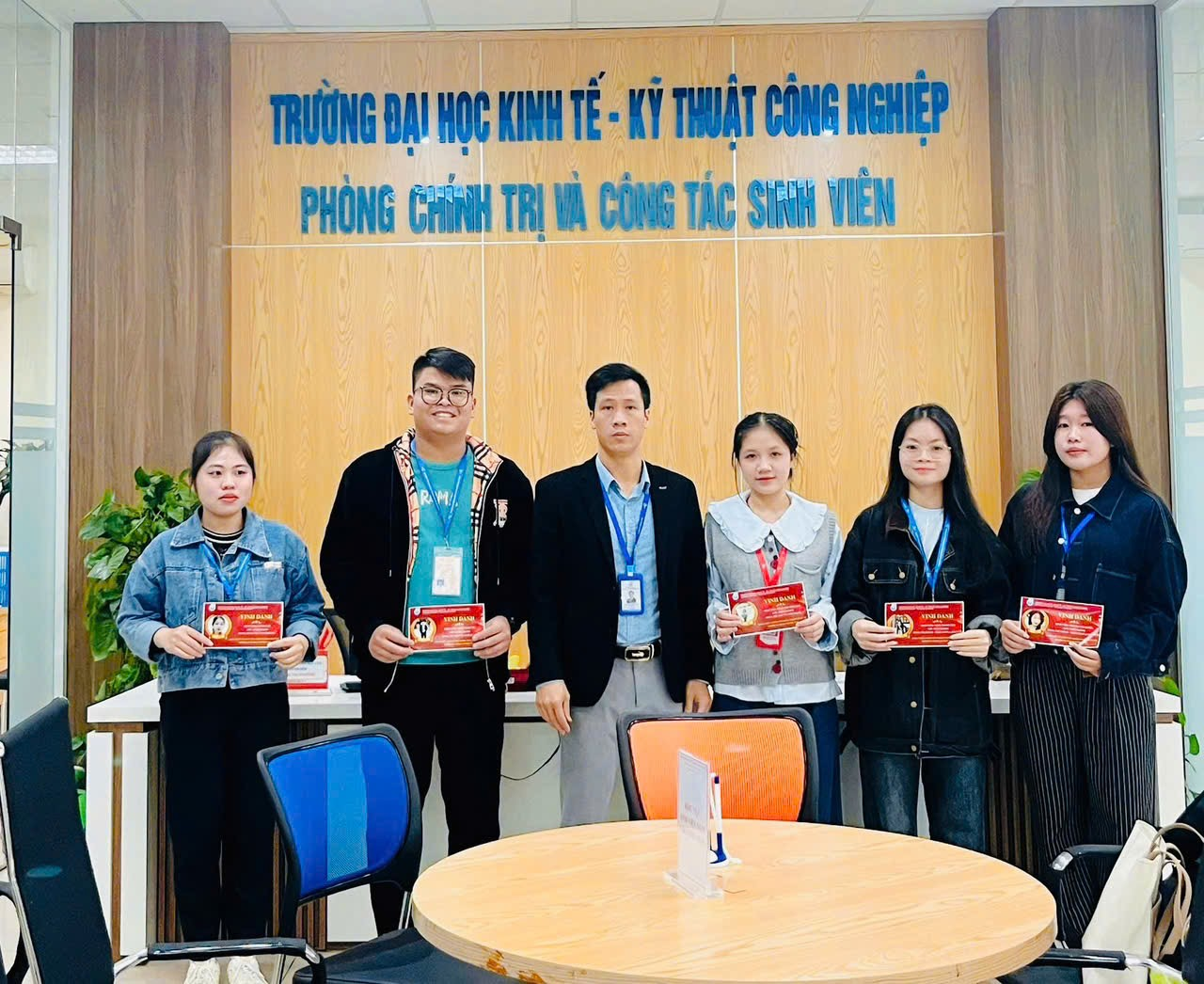 A group of people standing in front of a table Description automatically generated