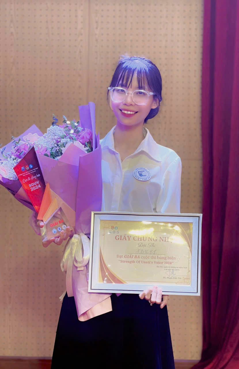 A person holding a bouquet of flowers and a certificate

Description automatically generated