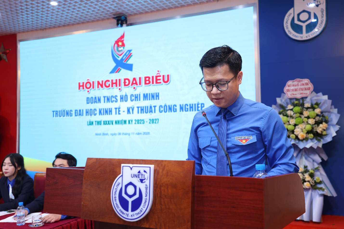 A person standing at a podium Description automatically generated