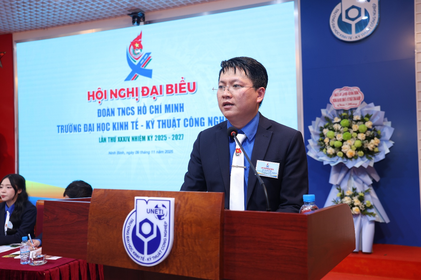 A person standing at a podium Description automatically generated