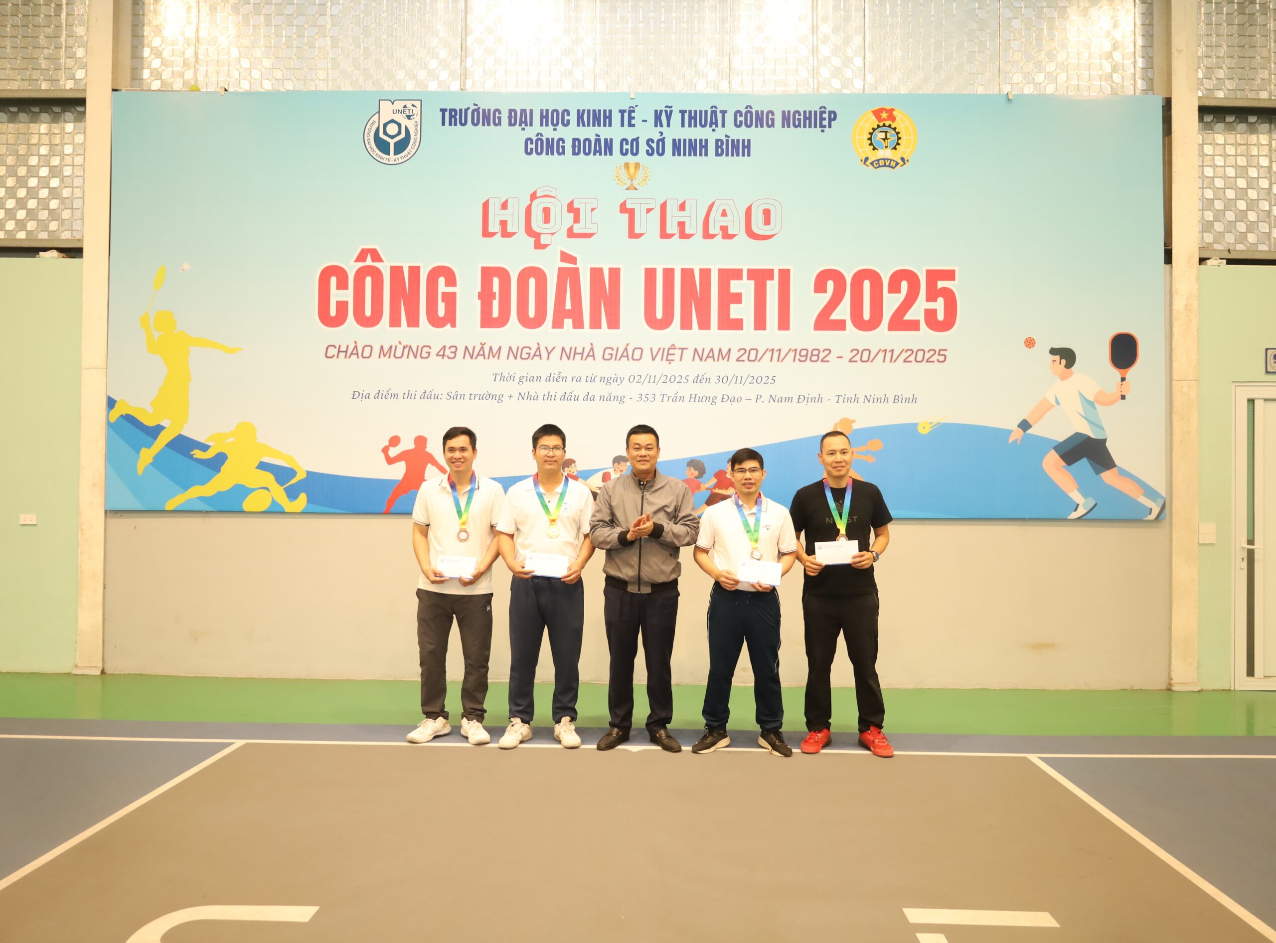 A group of men standing in front of a banner

Description automatically generated