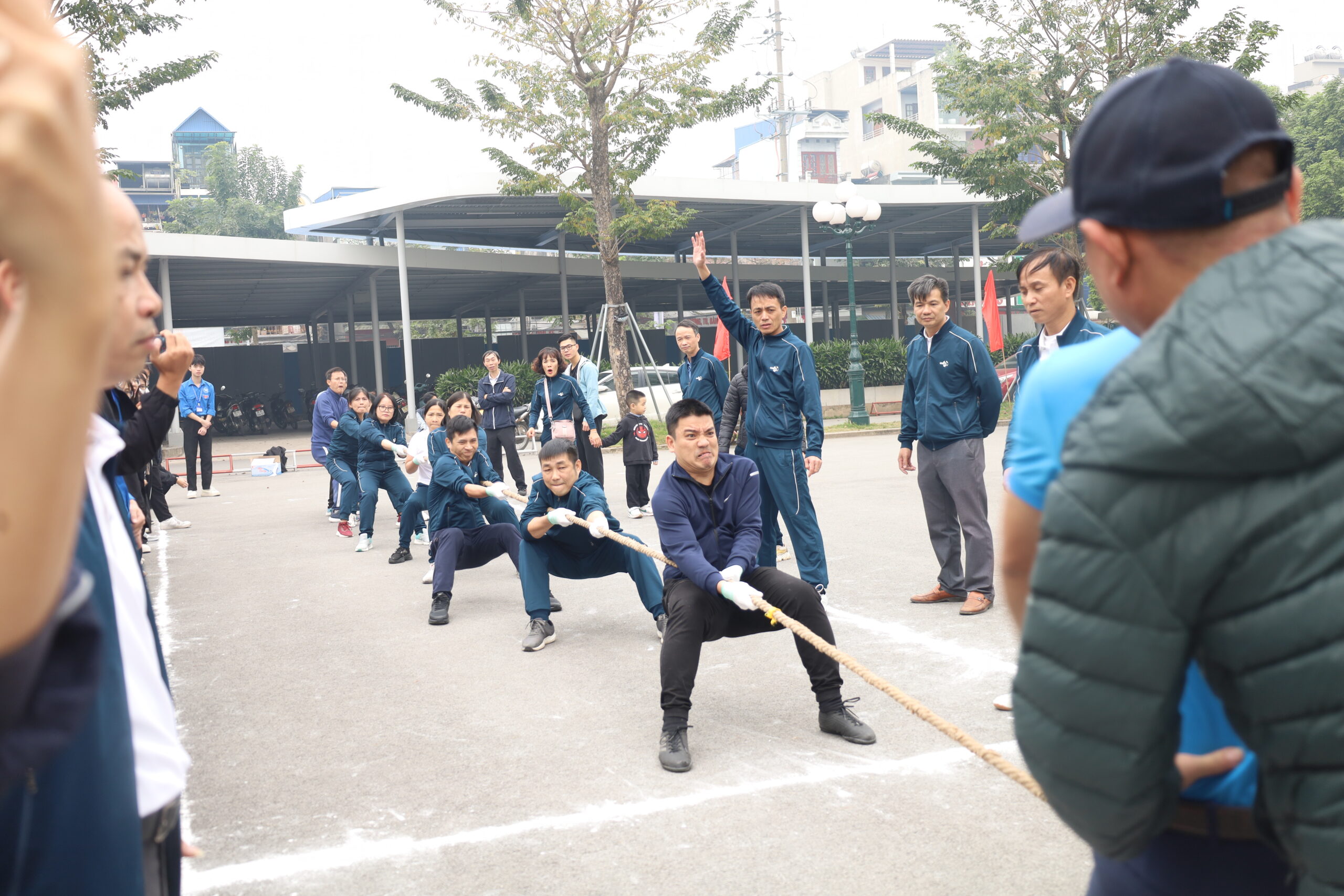 A group of people in uniform pulling a rope

Description automatically generated