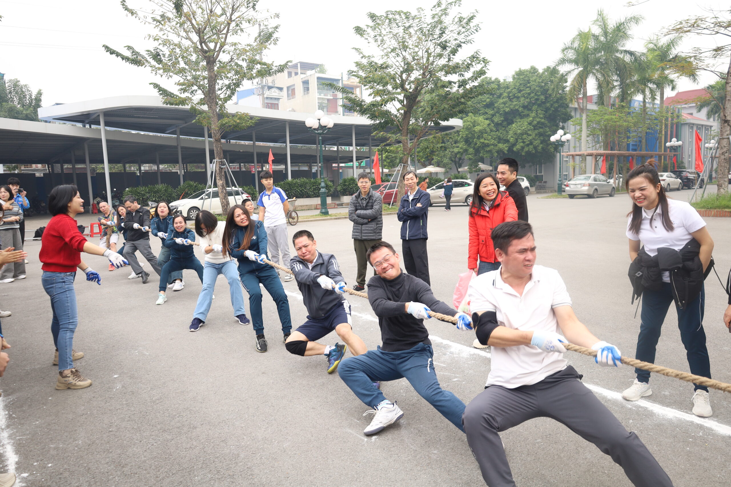 A group of people pulling a rope

Description automatically generated