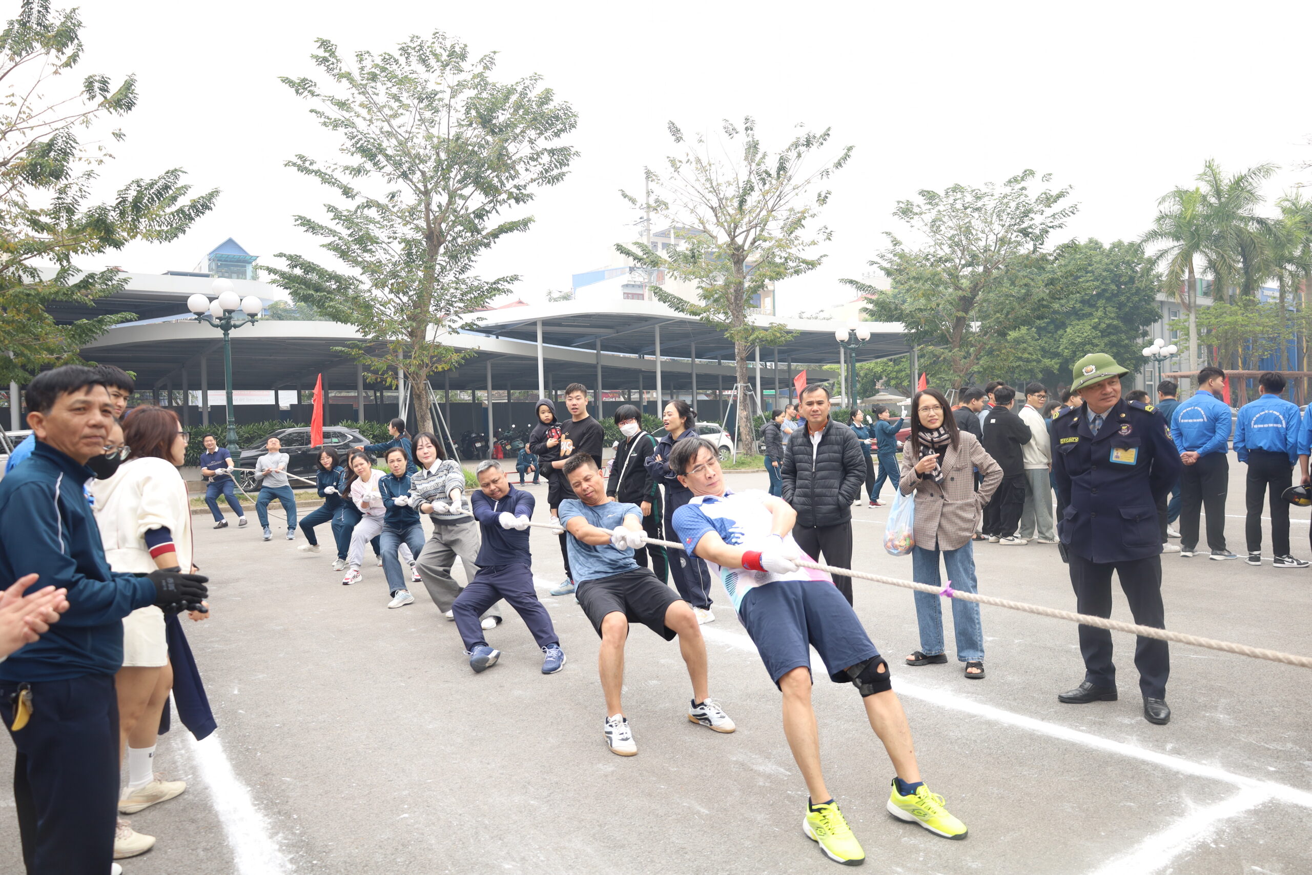 A group of people pulling a rope

Description automatically generated