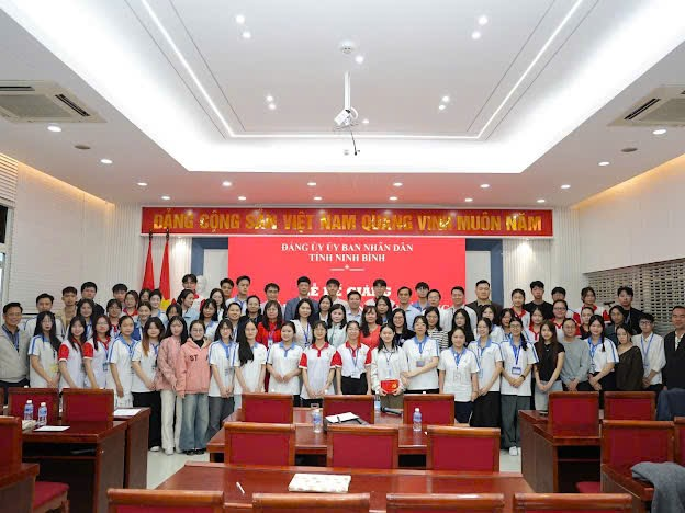 A group of people standing in a room Description automatically generated