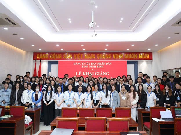 A group of people standing in a room Description automatically generated