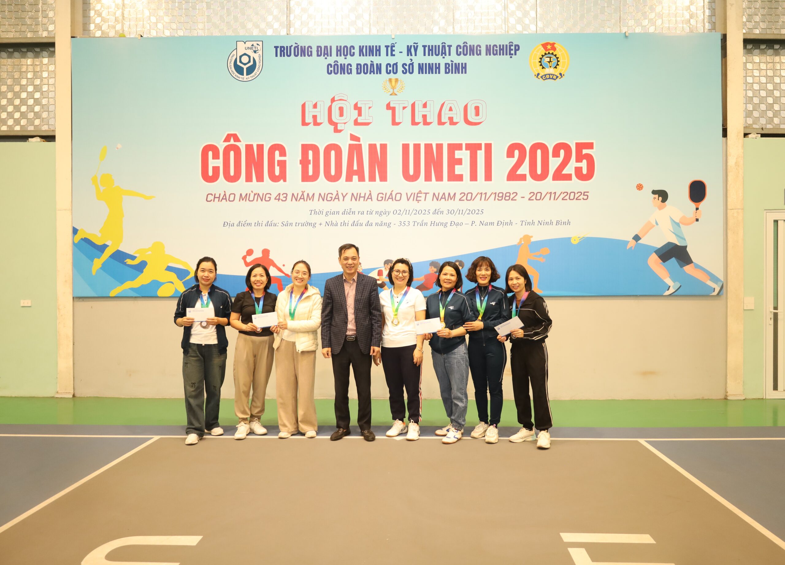 A group of people standing in front of a banner

Description automatically generated