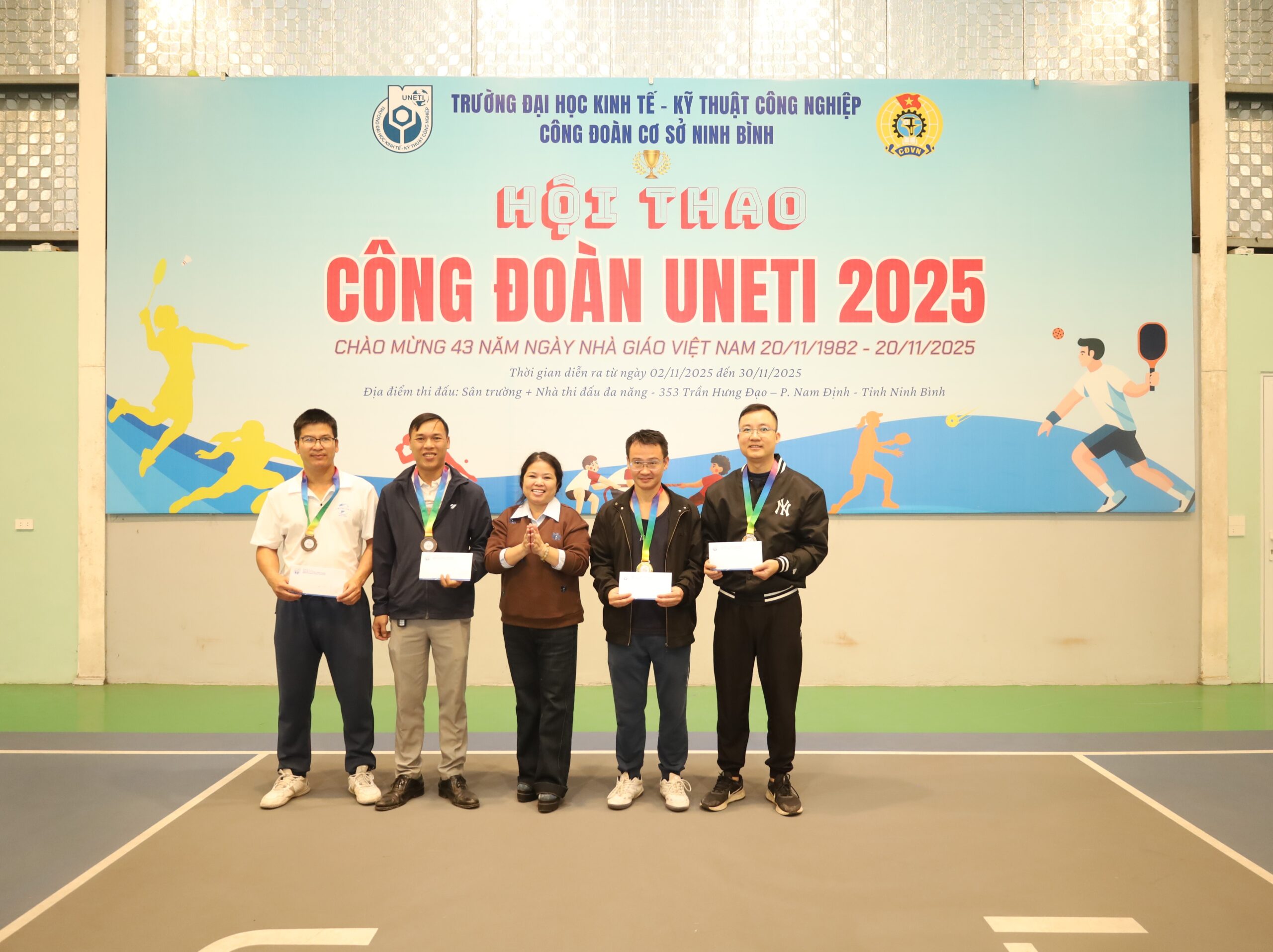 A group of people standing in front of a banner

Description automatically generated