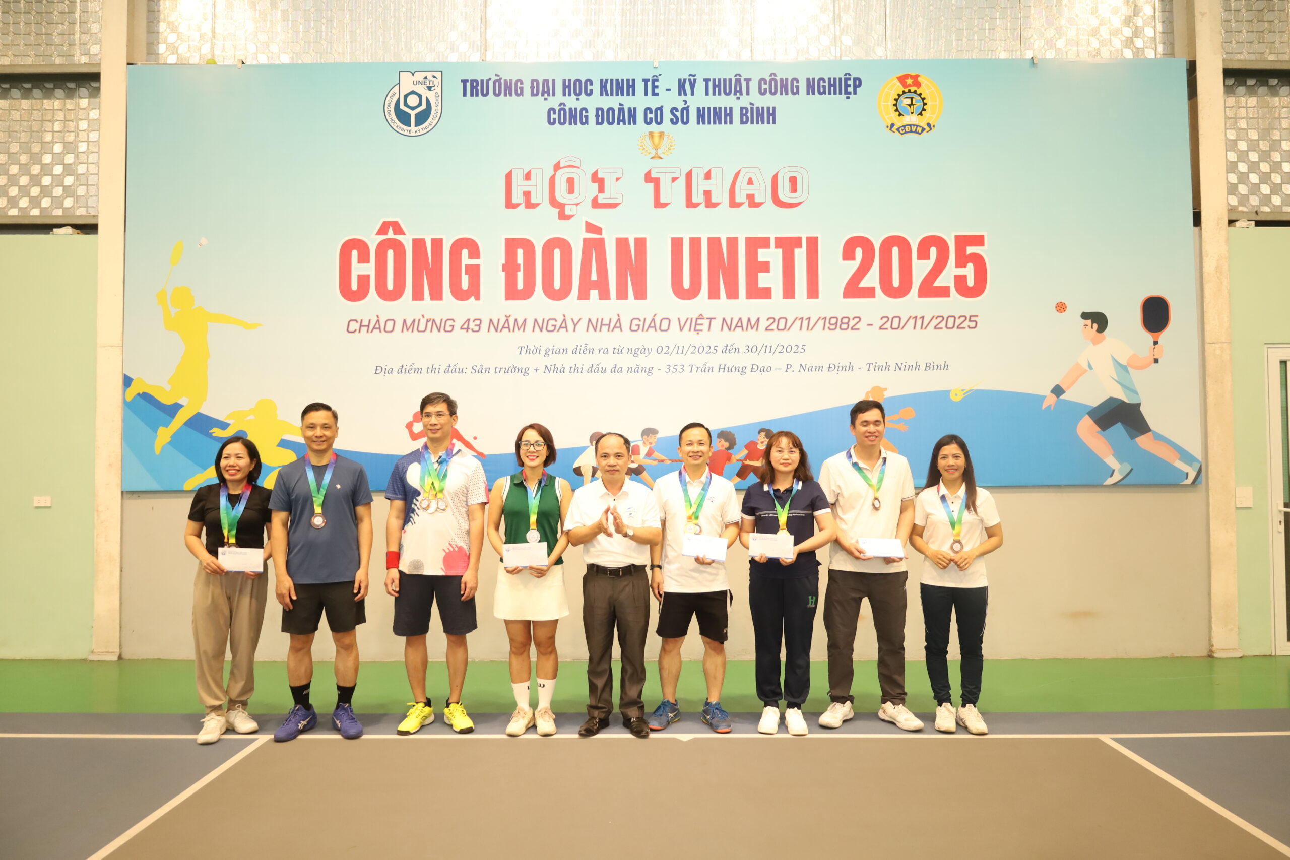 A group of people standing in front of a banner

Description automatically generated