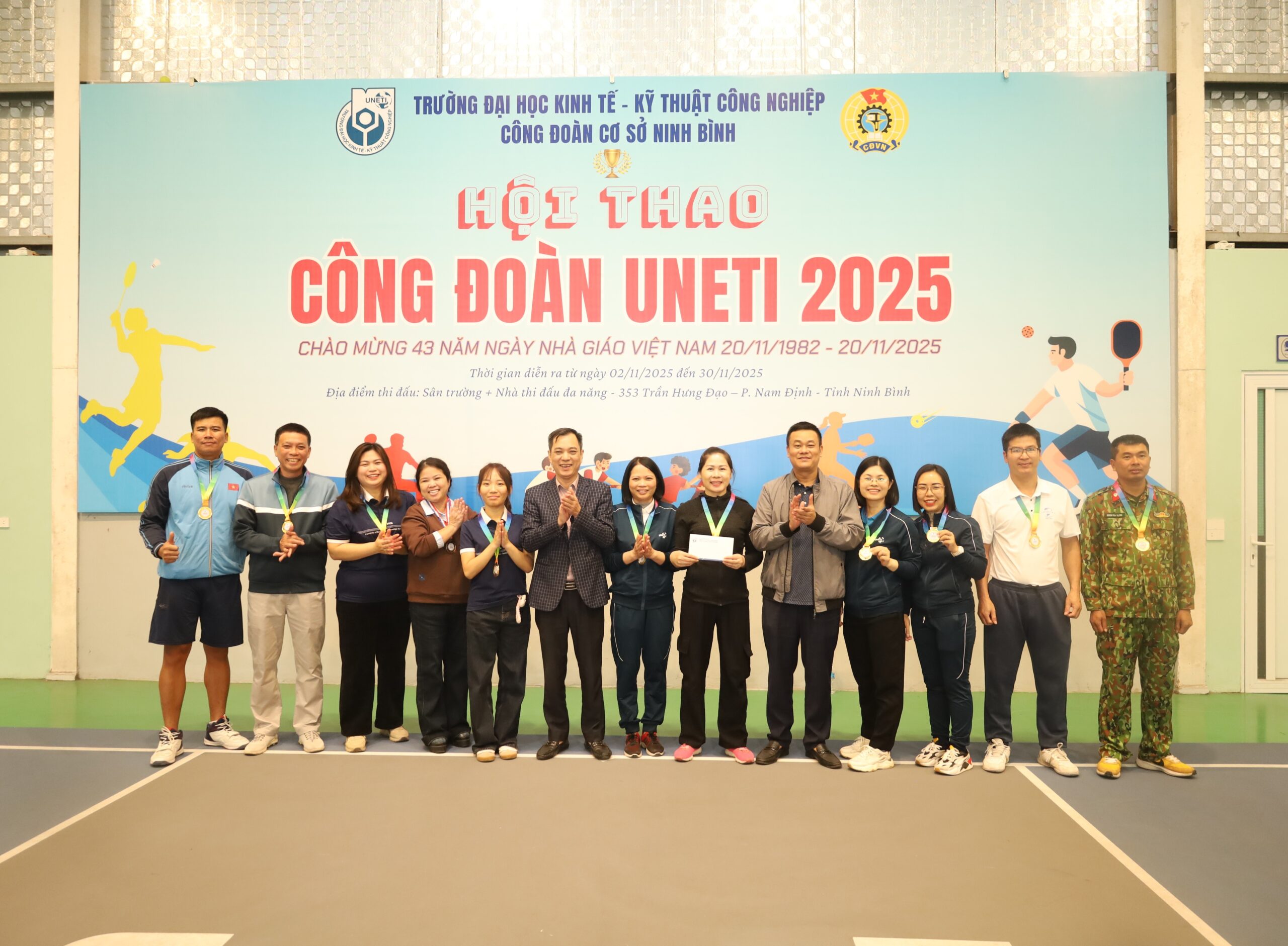 A group of people standing in front of a banner

Description automatically generated