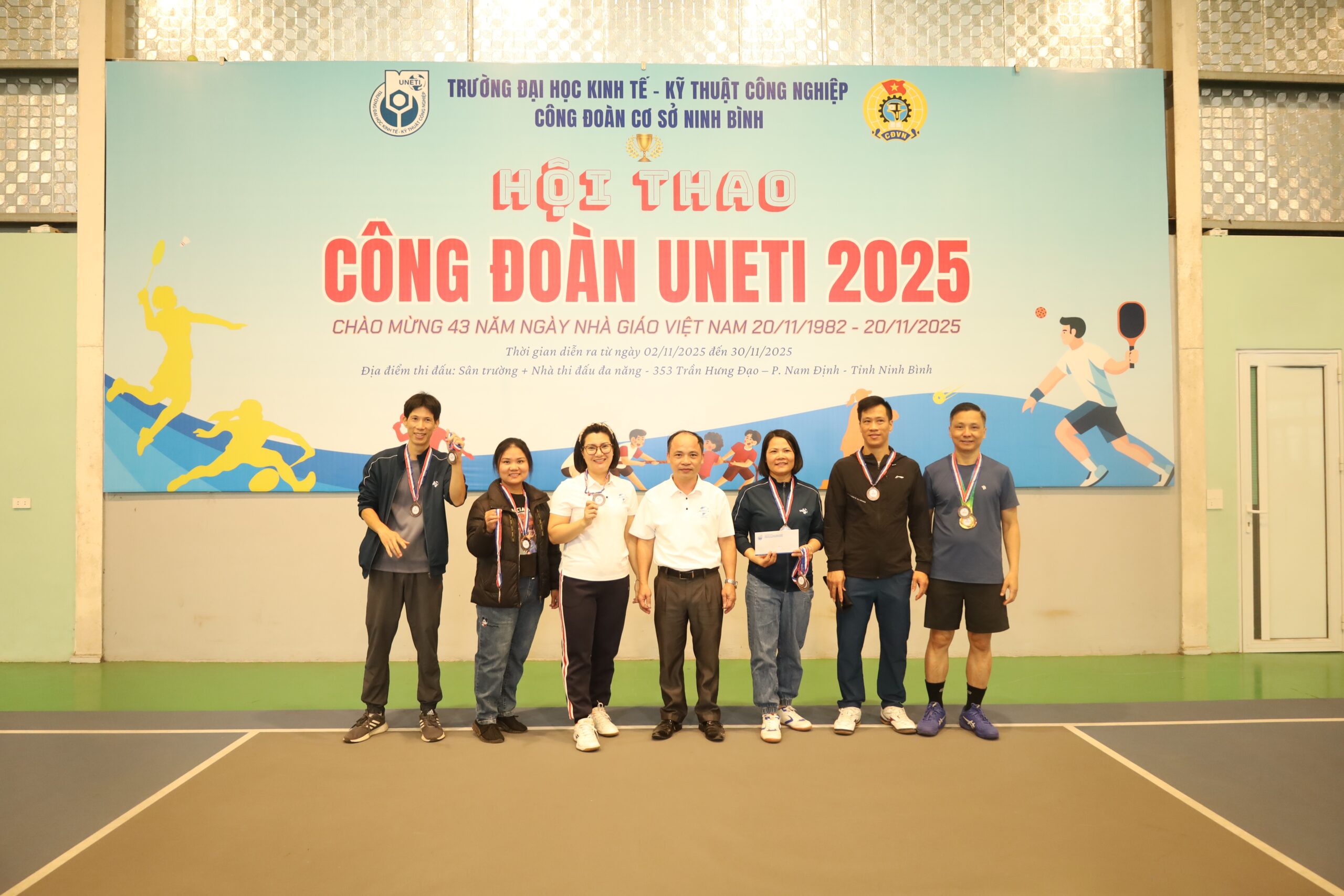 A group of people standing in front of a banner

Description automatically generated