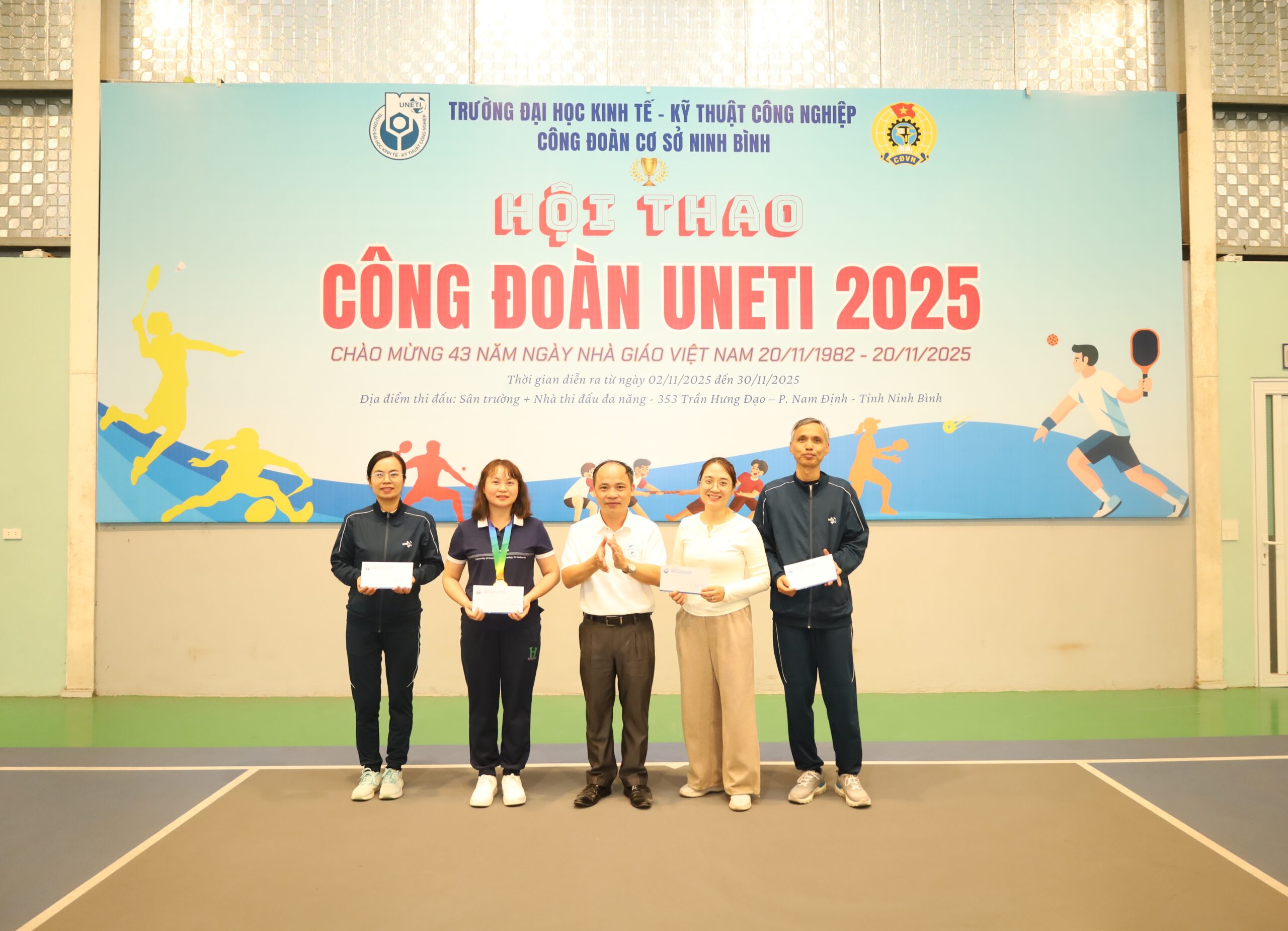 A group of people standing in front of a banner

Description automatically generated