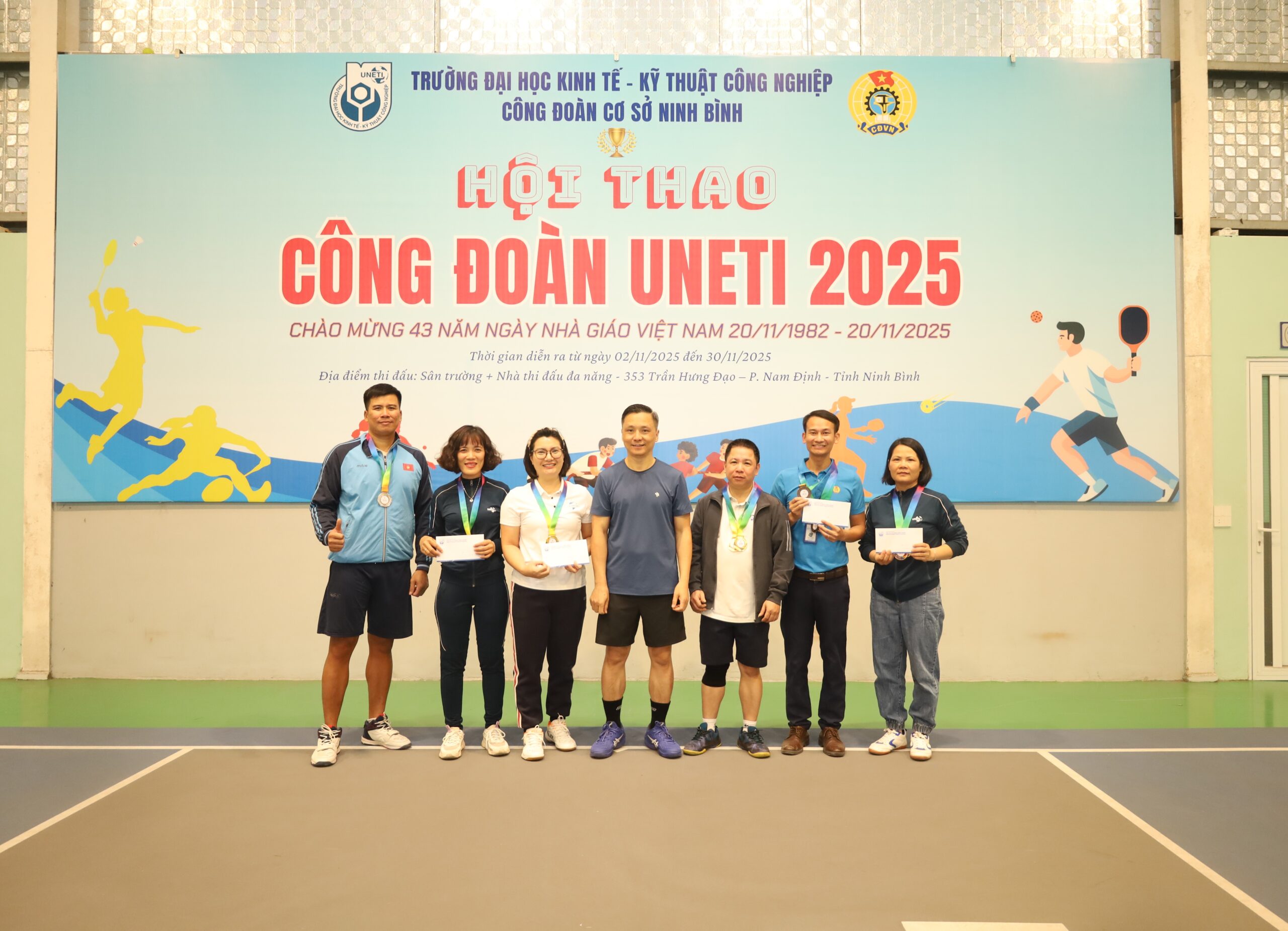 A group of people standing in front of a banner

Description automatically generated