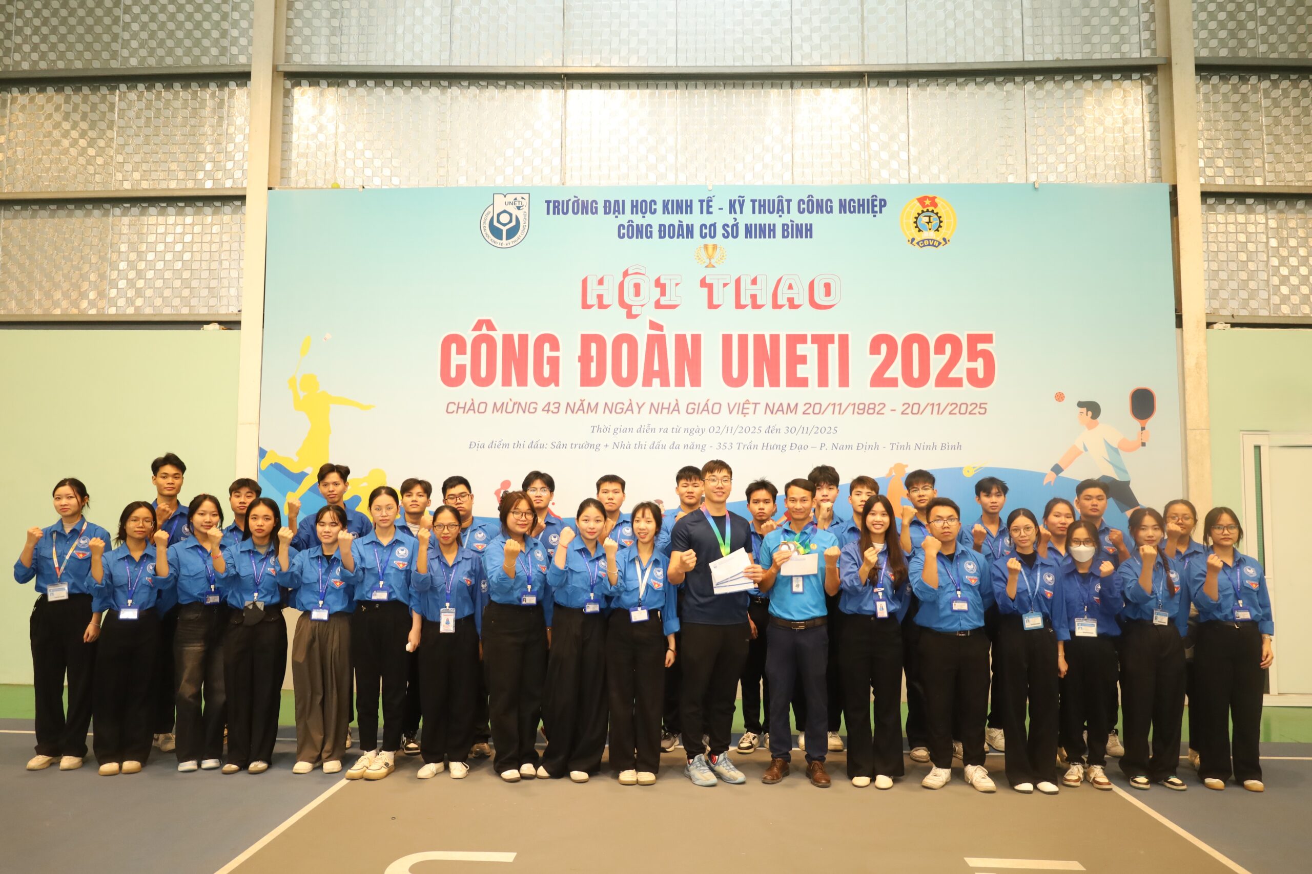 A group of people standing in front of a sign

Description automatically generated