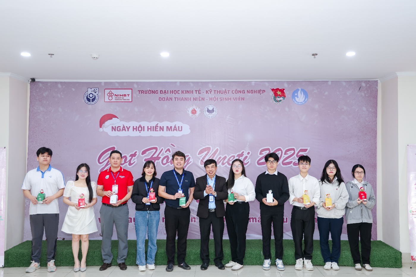 A group of people standing in front of a wall with signs Description automatically generated