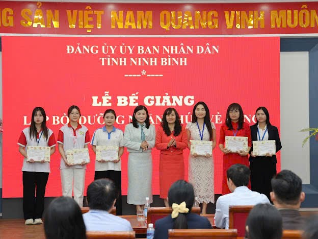 A group of women standing in a row holding certificates Description automatically generated