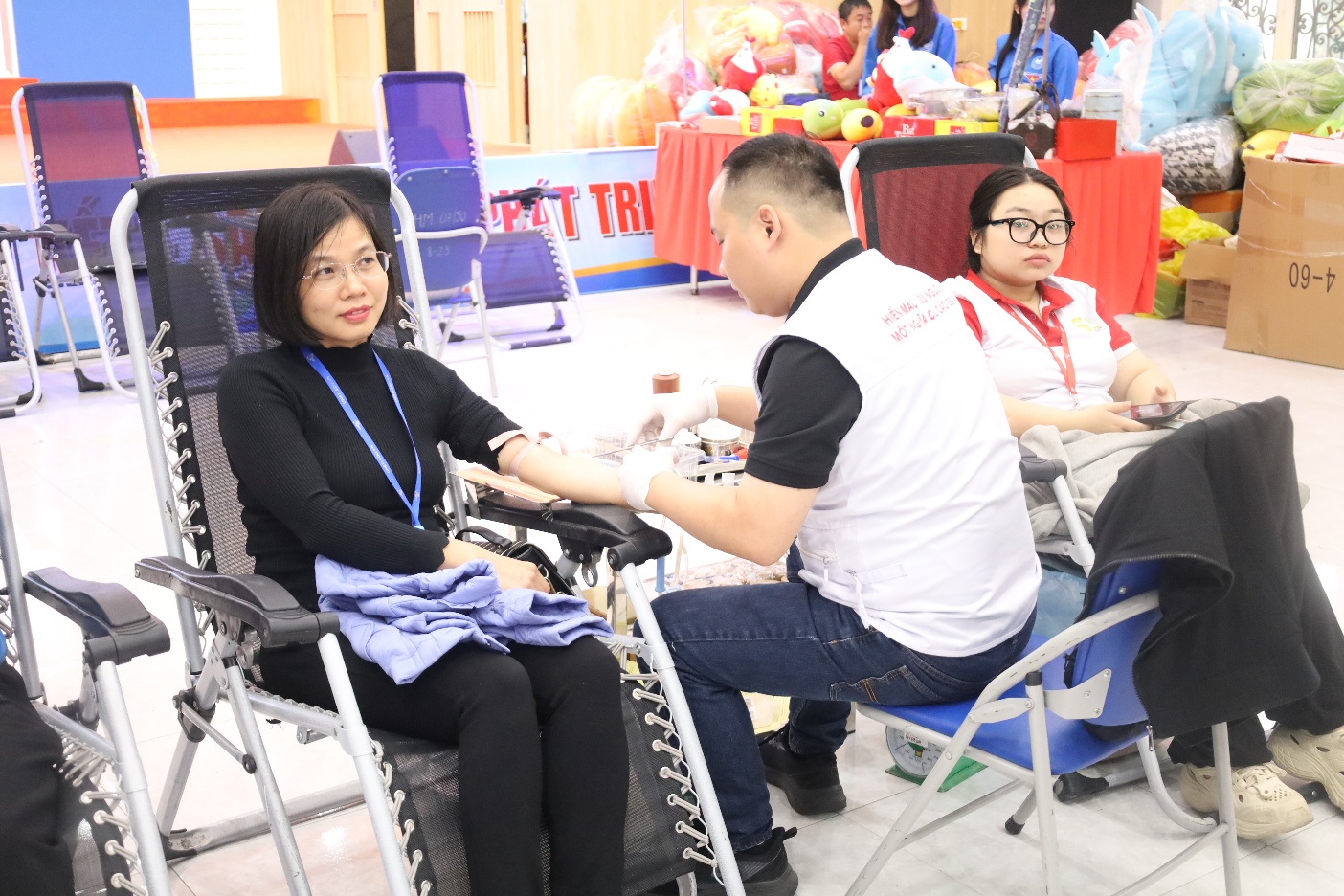 A person giving a blood sample to a person

Description automatically generated