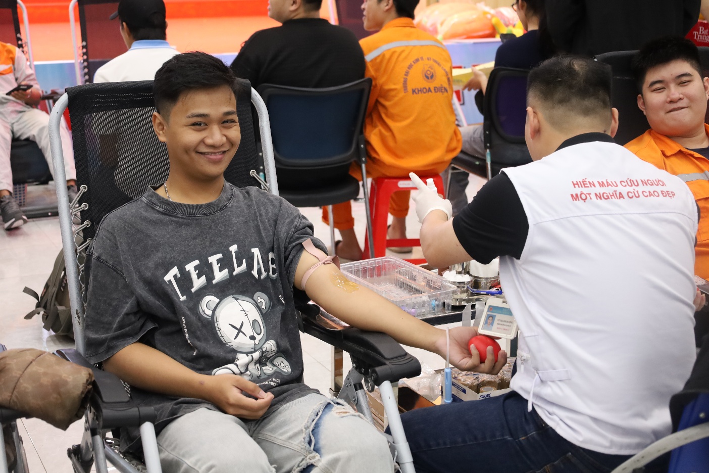 A person in a wheelchair getting blood from another person

Description automatically generated